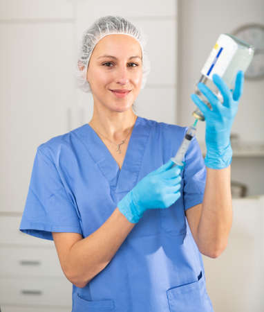 Positive nurse taking injection with syringeの写真素材