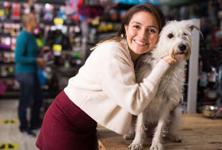 Portrait of woman with beloved dog in pet shopの写真素材