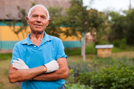 Elderly gardener posing in his gardenの写真素材
