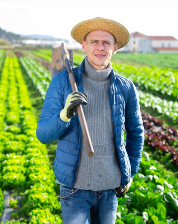 Man farmer with hoe in hand standing in the farmの写真素材