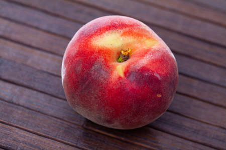 Closeup of whole ripe red peaches on wooden table.の写真素材
