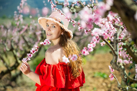 Young girl standing in spring blooming garden