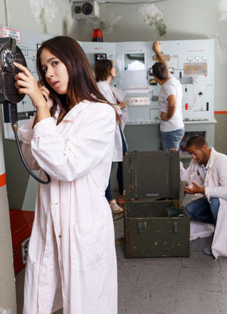 Young woman talking on telephone in lost room-bunkerの写真素材