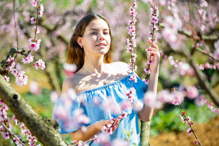 Girl in the spring garden peach in blue dressの写真素材