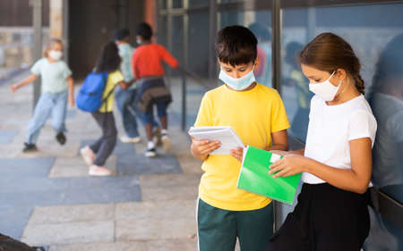 School children in masks talking outsideの写真素材