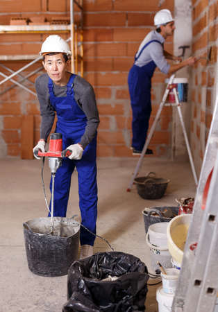 Two builders in process of finishing workの写真素材