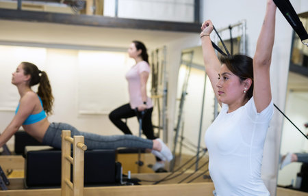 woman pilates stretching sport in reformer bed