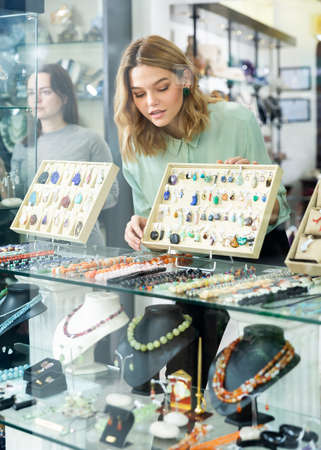 Saleswoman working behind window of jewelry shopの写真素材