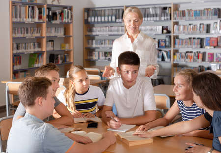 Group of nice schoolers discussing with teacherの写真素材