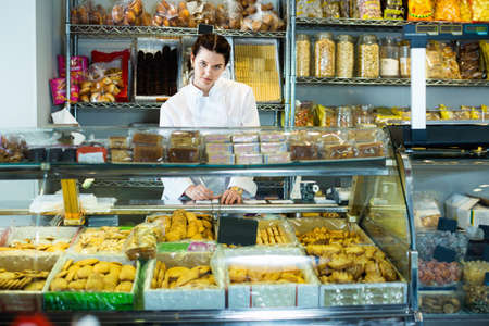 Young woman selling cookies and other fillingsの写真素材
