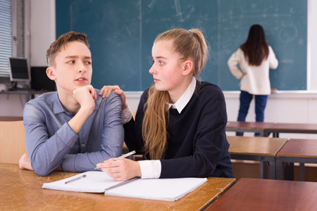 Female classmate calming frustrated teenagerの写真素材