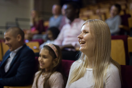 caucasian woman laughting at premiere in theatrical hall