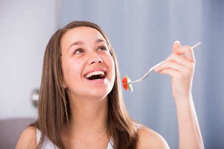 Smiling woman is enjoying tasty green saladの写真素材