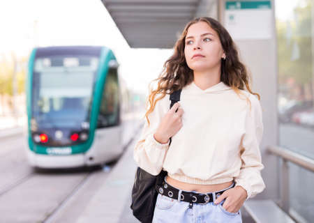 Portrait of a girl walking along a tram stopの写真素材