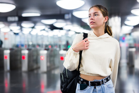 Younh female passing the turnstiles at subway station