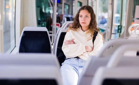 Young positive woman traveling in tramの写真素材