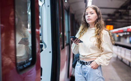 Woman entering the door of the modern train in subwayの写真素材