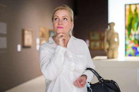 Portrait of senior woman visiting exposition at museumの写真素材