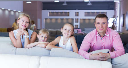 Family are choosing new sofa in furniture store.の写真素材