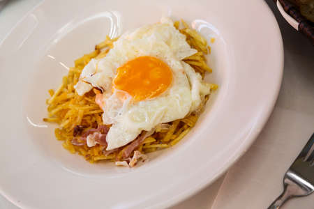 Spanish fried egg with fries and jamonの写真素材