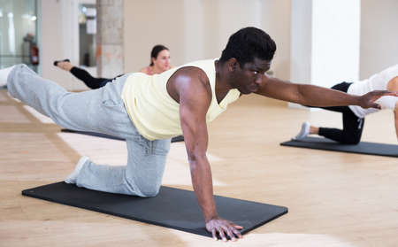 African American man doing pilates exercises with groupの写真素材