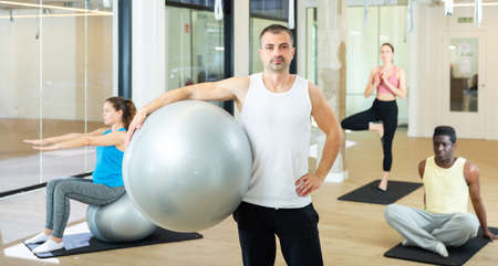 Man standing with pilates ball at gymの写真素材