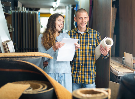 Married couple shopping at a hardware store checking list on paperの写真素材
