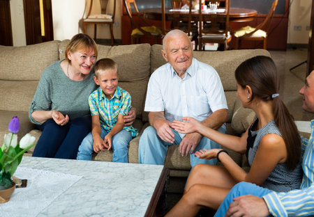 Senior woman and man talking to children and grandsonの写真素材