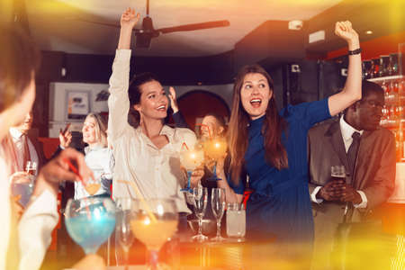 Young attractive women with cocktails having fun with workmateの写真素材
