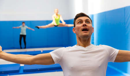 Portrait of excited man jumping on trampolineの写真素材