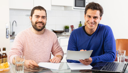 Men discuss and sign apartment sale contract agreement at home