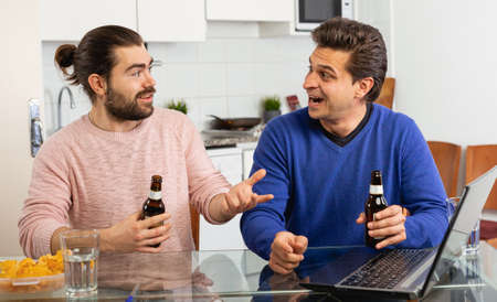 Two men friends are talking and drinking beerの写真素材