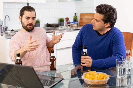 Two friends with bottles of beer celebrate happy event