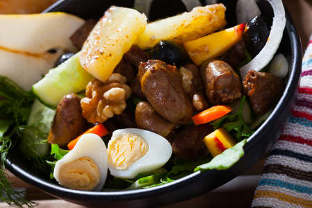 Chicken hearts salad with peach, pear, grilled cheese and quail eggsの写真素材