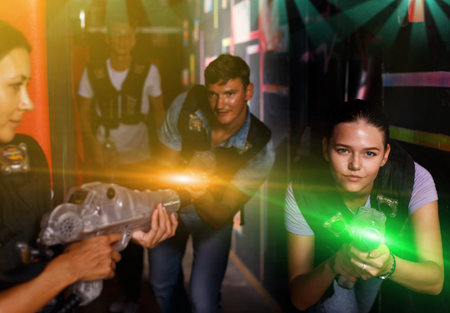 friends standing with laser guns during laser tag game