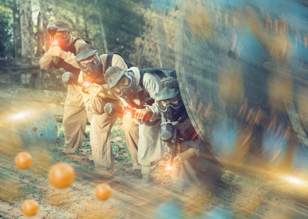 Paintball team aiming outdoors