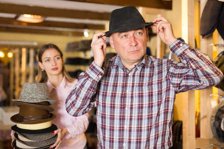Man trying on hat in shopの写真素材