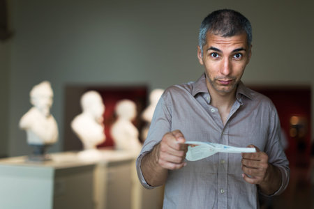 Adult male is visiting at the pictures exposition with brochureの写真素材