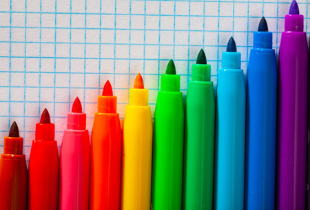 Image of opened multicolored markers on notebook, nobody