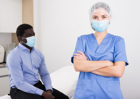 Confident female cosmetologist in medical office with male clientの写真素材