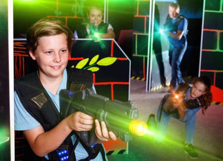 Excited boy aiming laser gun at other players during laser tag gの写真素材