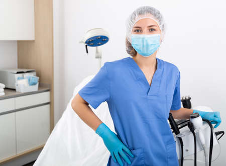 Confident female cosmetologist standing in medical aesthetic officeの写真素材