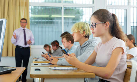 Teenage students using smartphones during lessonの写真素材