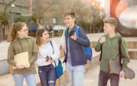 Carefree teen students walking outside schoolの写真素材