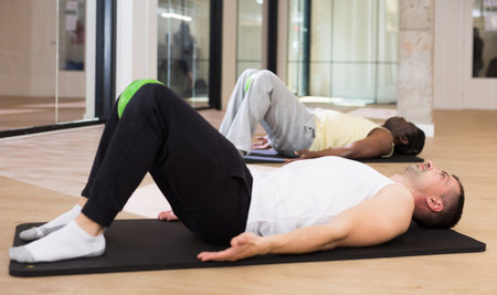 Sporty man doing exercises with pilates ball