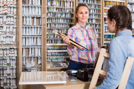 female seller displaying various items in art shopの写真素材