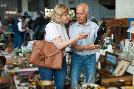 Mature man and his wife are visiting market of old things