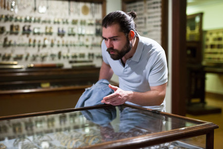 Adult man looking at exhibits in glazed stands in historical museum