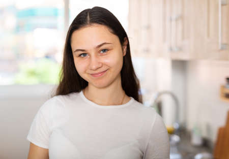 Portrait of young woman posing in kitchenの写真素材