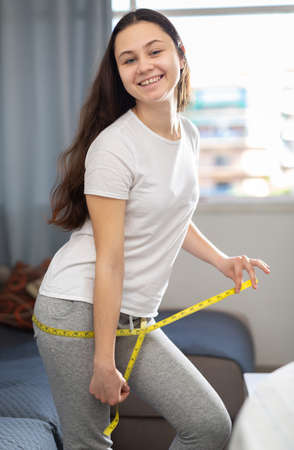 Portrait of woman taking measurements of bodyの写真素材